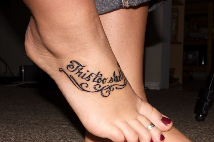 napis na tatuaż, mały tatuaż na stopie, srebrny pierścionek