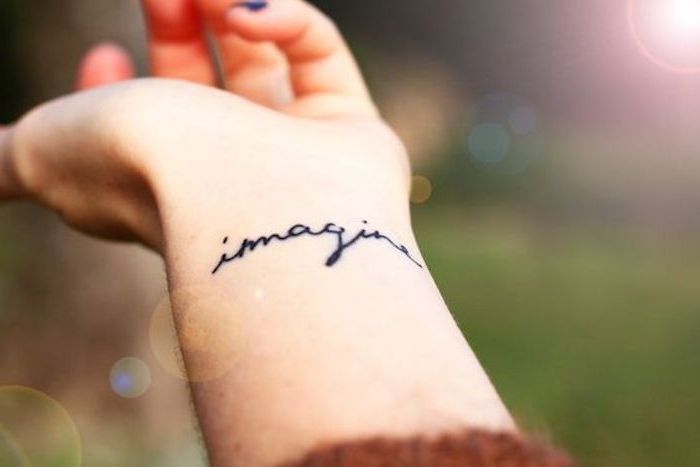 napis na tatuaż, mały tatuaż na ramieniu, kobieta