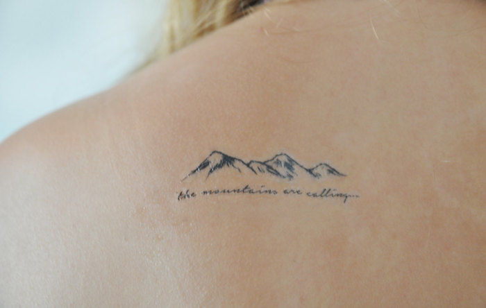 o poza cu un munte si un tatuaj care spune ca spune - muntele este de asteptare