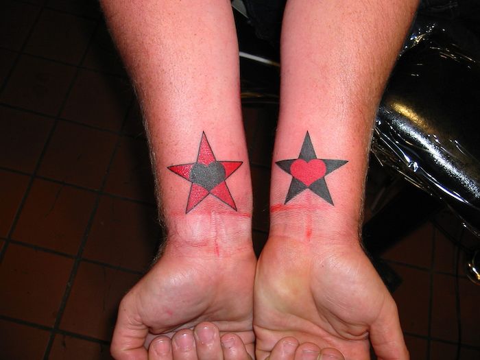 een dode ster met een zwart hart en een zwarte ster met een rood hart - handen en ster-tatoeage