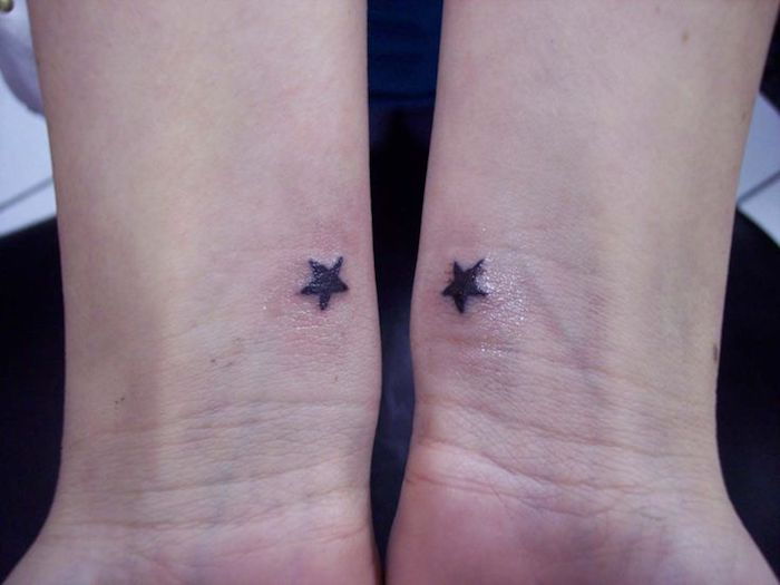 twee handen met tatoeages met twee kleine zwarte sterren - tatoo sterren pols
