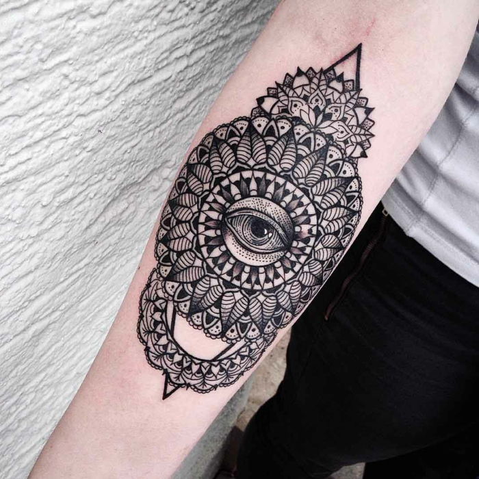 Tatuagem longa do braço da tatuagem, duas pontas pretas na parte superior e inferior, uma pirâmide, muitas linhas pretas e um olho cansado