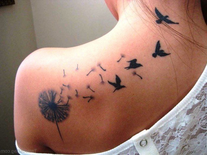 Femeie cu tatuaj de păsări pe spate, minge de suflare cu semințe și păsări zburătoare