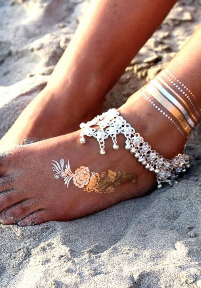 piedini della donna della spalla del tatuaggio i piedi con le decorazioni decorano invece l'autoadesivo dorato dei gioielli