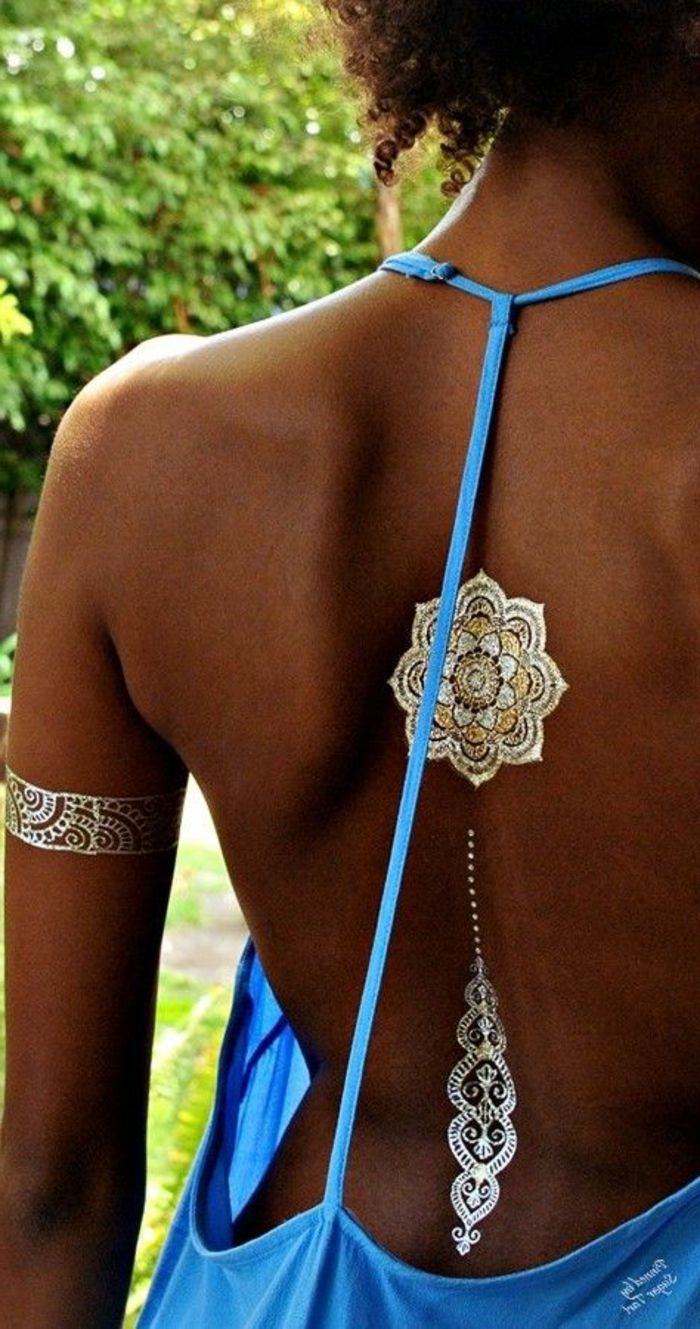 tatovering skulder kvinne blå kjole vakre tatovering ideer på baksiden armbånd sølv gylden krøllete hår