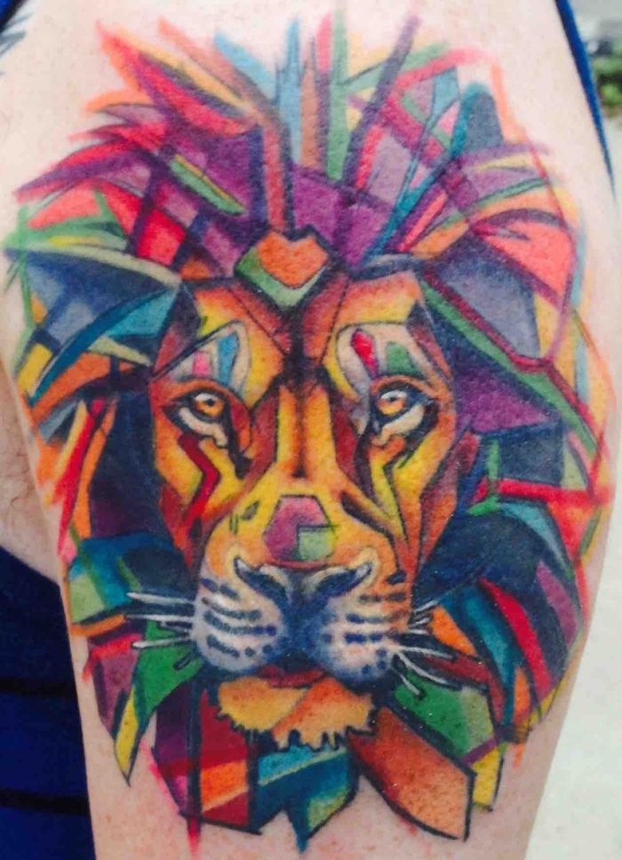 et løve med mane laget av geometriske former i mange forskjellige farger. Akvarell tatovering