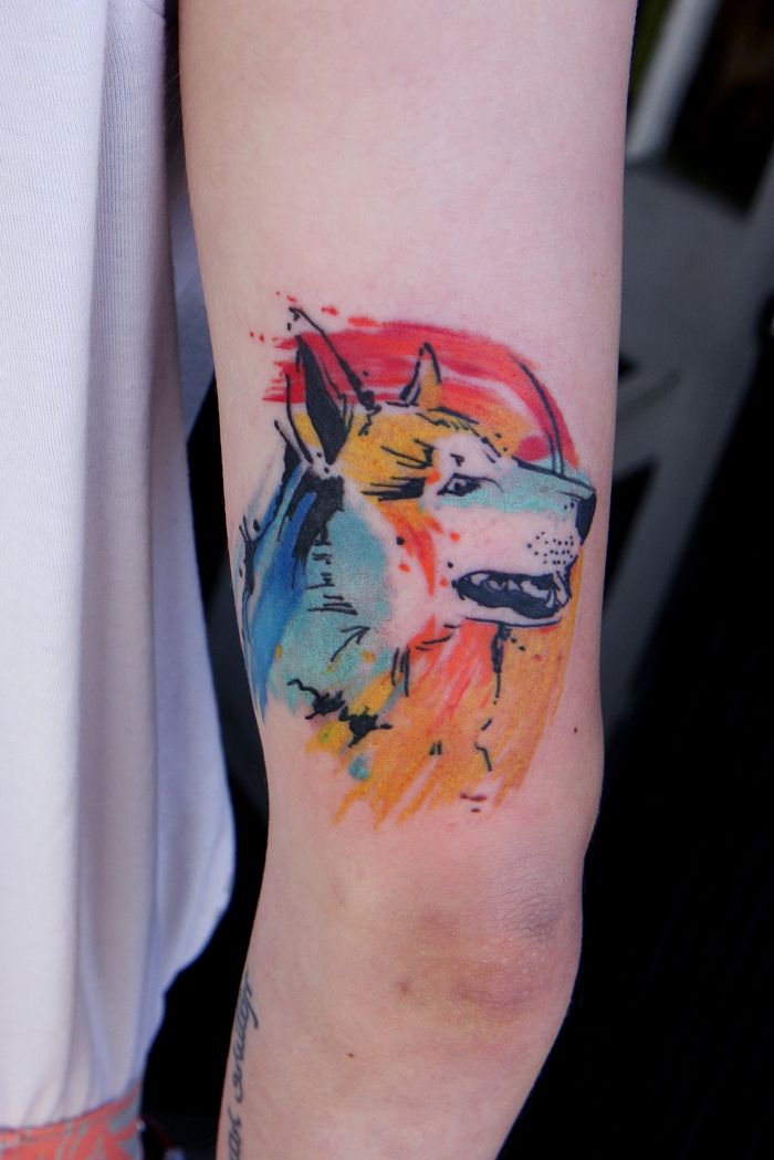 en hund av fyra färger omger vacker akvarelltatuering av husdjur