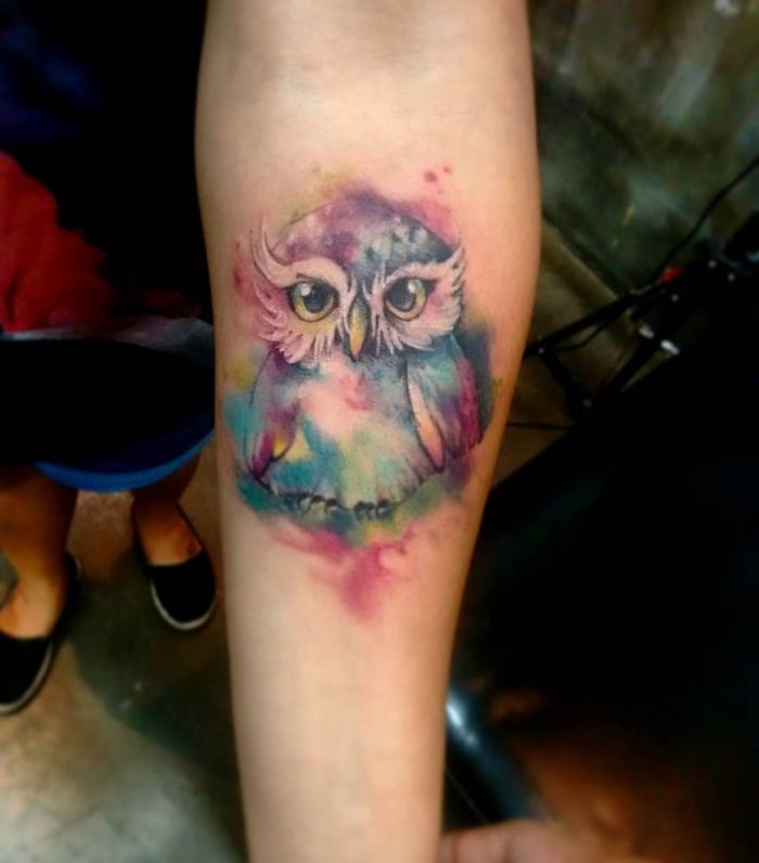 Akvarell tatovering av en liten ugle med store øyne i mange farger