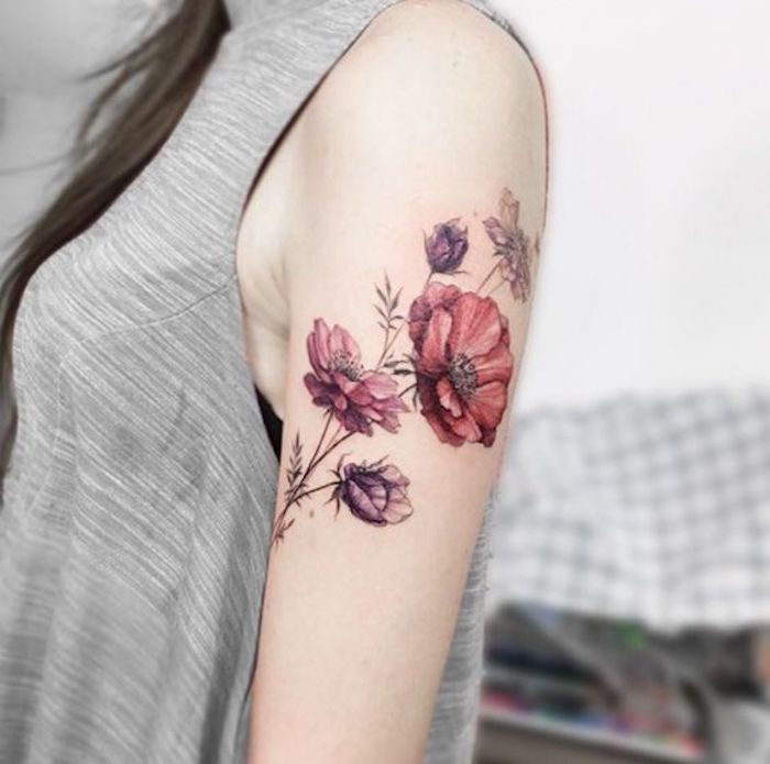 Kvinna med hudprydnad på axeln, röda och lila blommor