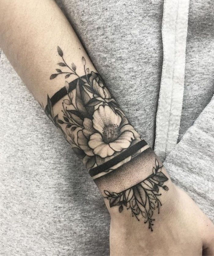 bloemen en hun betekenis, zwart en grijs armband tattoo op onderarm