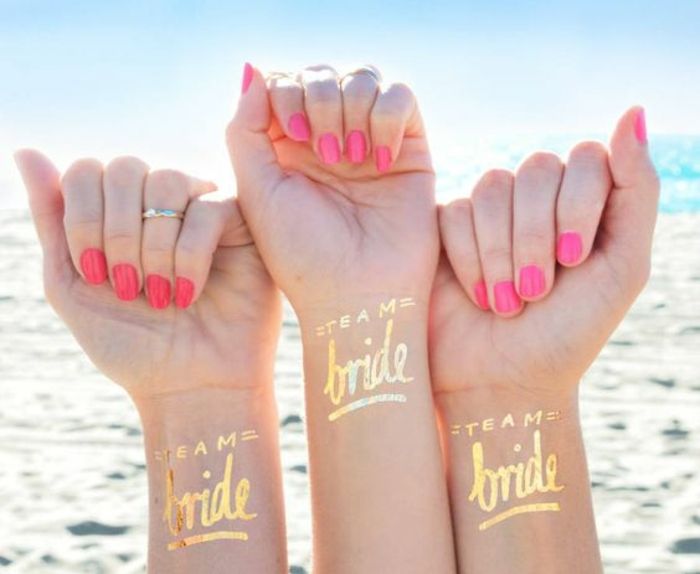 vakre tatoveringer gyldne minitattoos fargerike negler rød rosa gylden ring overraskelse fest for bruden