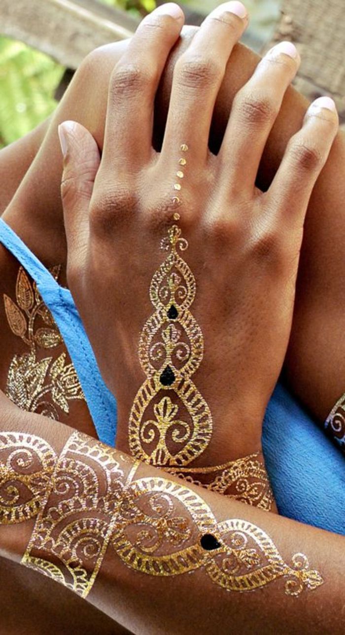 krásne tetovanie v zlatých farbách umiestnené na rukách držať na ozdobte ruky telo