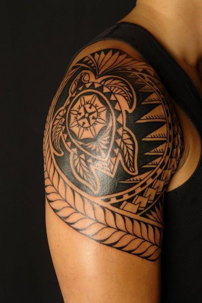 Človek z ramenskim tatoo s starimi plemenskimi elementi, želva