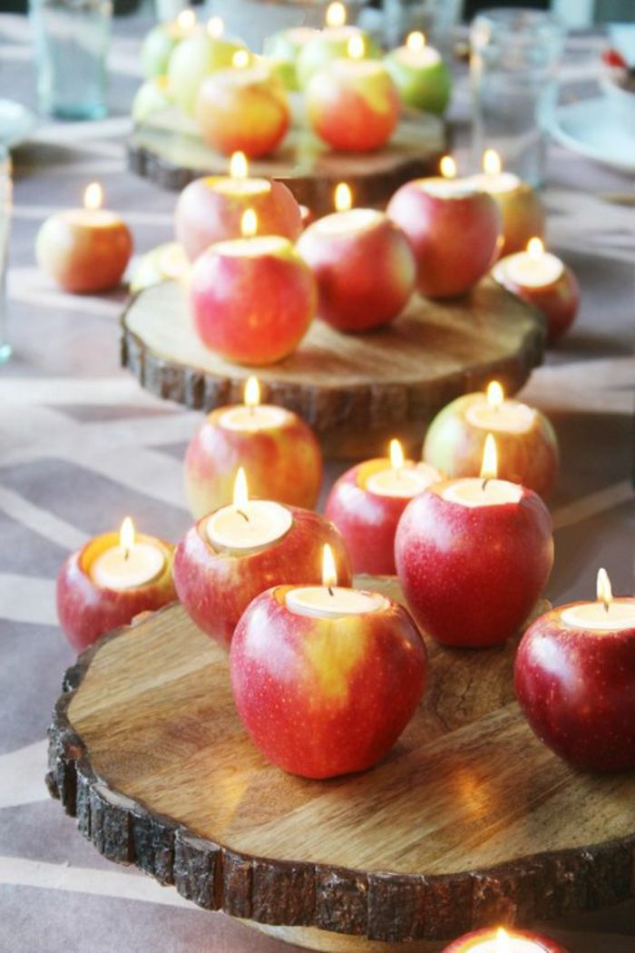 Decoração de mesa, muitas maçãs, documentos de madeira, velas, tealights