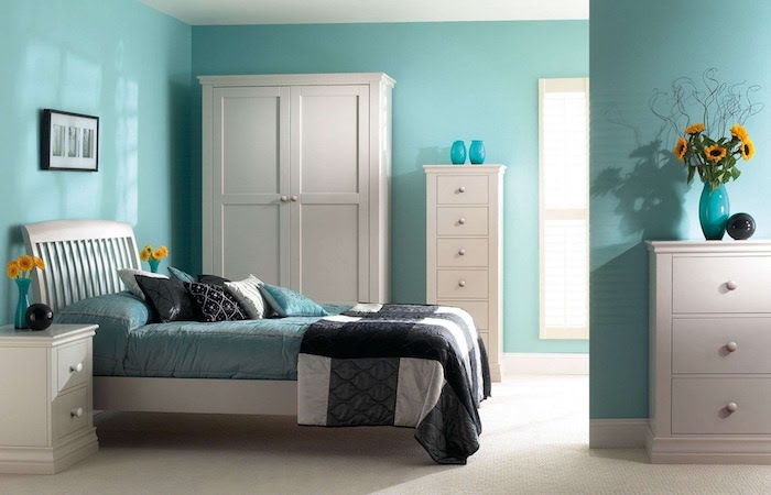 trevliga rum med blåa väggar, en vit garderob, färgstarka lakan