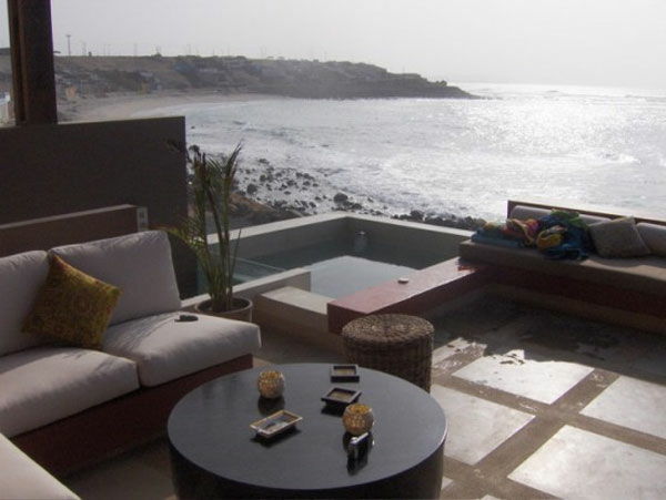 imagem moderna terraço - sogas, almofadas, mar e uma piscina