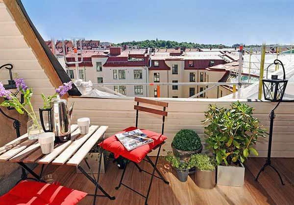 Mooi balkonontwerp met een houten tafel en rode accenten