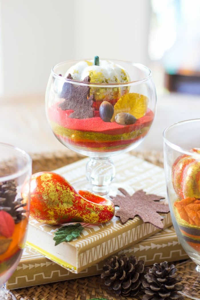 Naplňte sklenené poháre s žaludmi, kužeľmi a drobnými tekvicami, usporiadajte stôl jesenne, myšlienky na DIY
