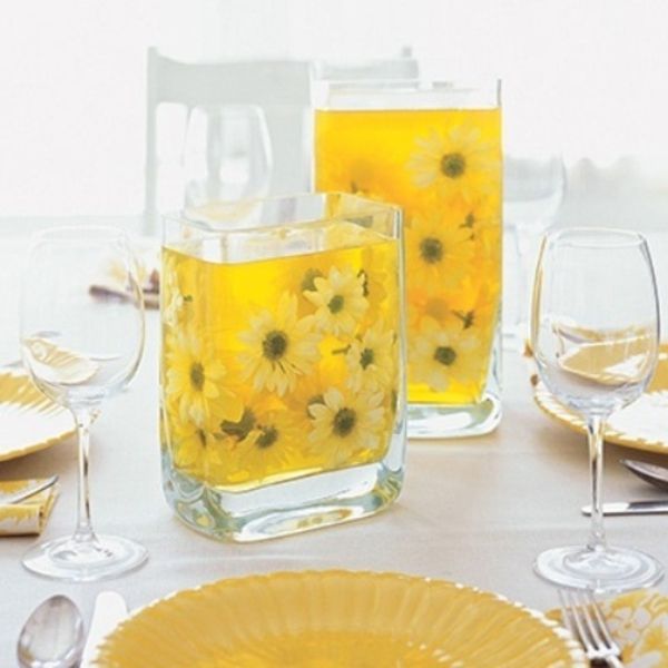 stalas gražus dekoravimo vazos su gėlėmis - geltonos spalvos balta staltiesė