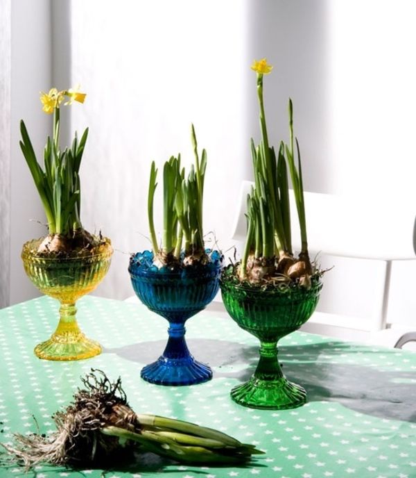 stalo dekoravimas su stiklinėmis spalvotomis vazomis ir šaknimis