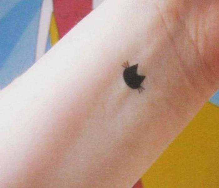 Iată un tatuaj de pisică neagră pe o parte - o pisică neagră cu cozile negre lungi pe cocoșul lui