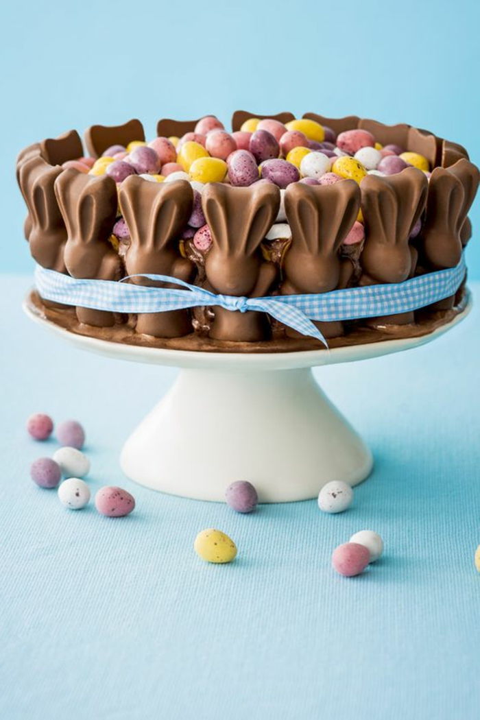 Wielkanocny tort dekorujący z Easter królikami i kolorowymi Easter jajkami na białym tortowym stojaku