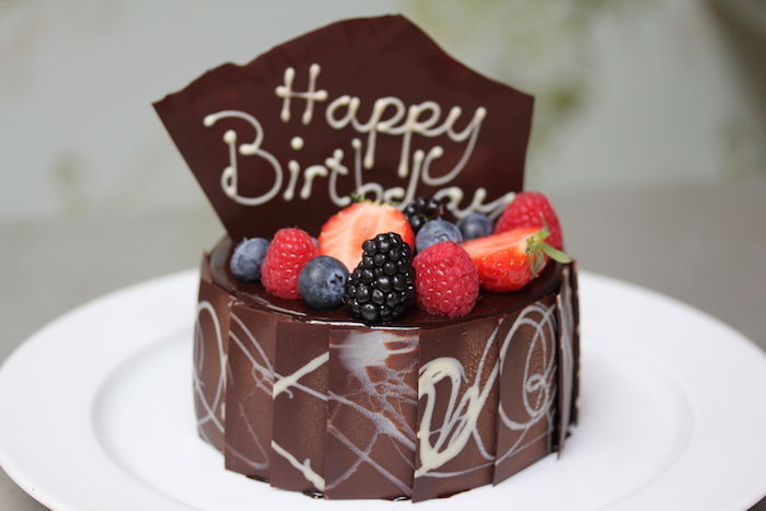 födelsedagstårta med choklad, jordgubbar och hallon