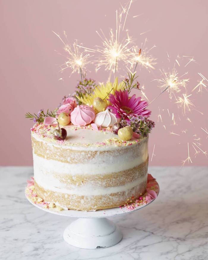 födelsedagstårta med vaniljskikt dekorerad med blommor och smörgås