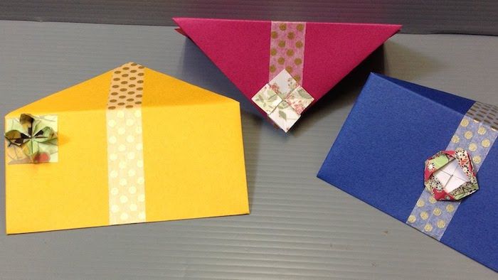 Tre kuvert i tre färger med små dekorationer från origami figurer - gör kuvertet själv