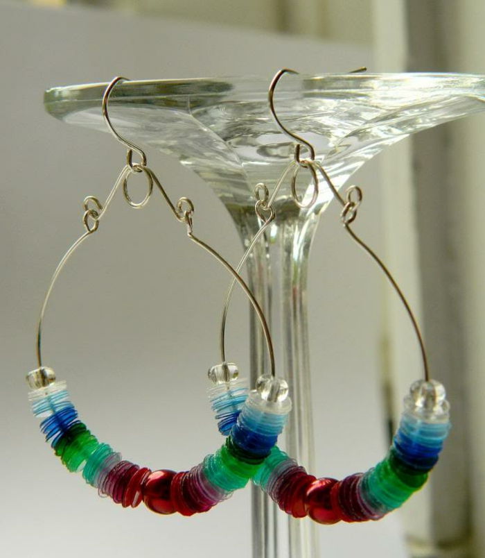 diy sieraden, grote zilveren oorbellen met elementen van plastic en glaskralen