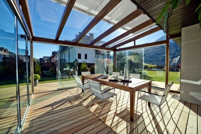 veranda įstiklinimas-medienos-grindys-ir-didelis-medienos-stalo su-sėdėjimo