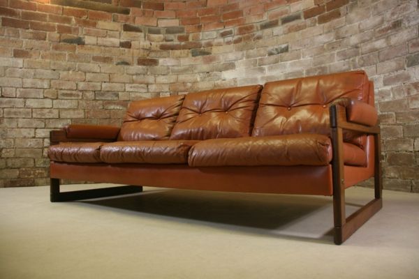 vintage-lederen meubels-sofa-in-brown-nuances- een bakstenen muur erachter