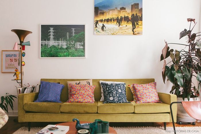Stilingas gyvenamasis kambarys, gražus namų dekoras, žalia sofa, spalvingos dekoratyvinės pagalvės, kambariniai augalai