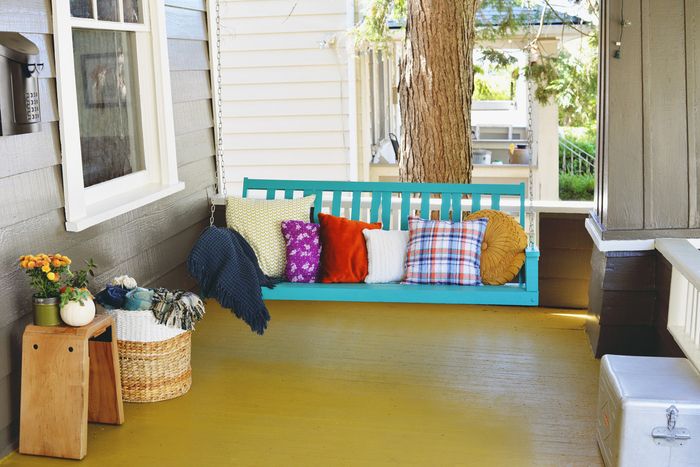 Vintage terasa, sūpynės su dekoratyvinėmis pagalvėlėmis ant jos, švieži ir spalvingi, nedideli balkonų augalai