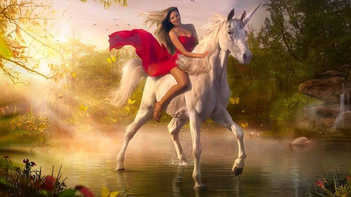 Kırmızı bir elbise ile genç bir kadın - yoğun bir yele ile vahşi beyaz bir tek boynuzlu at