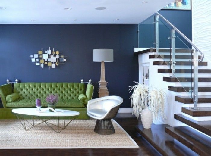vägg färg blå-grön-stoppade soffa-mattan-cream-vitt läder stol-mörkt trä golv trappor-glasgelaender-Stehlampe dekorativ vas-Wanddeko