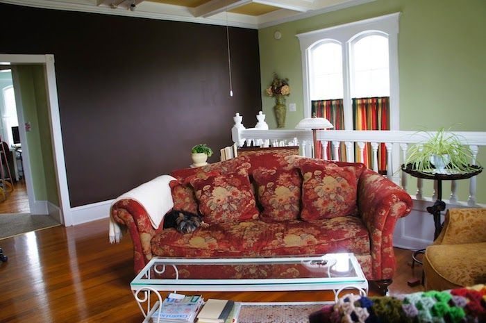 barvit kavč s cvetličnim vzorcem in steno v barvi barve v dnevni sobi