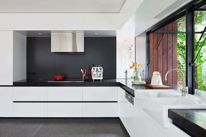 virtuvėje su netiesioginiu apšvietimu esanti juodos spalvos siena