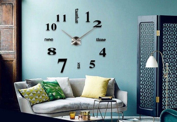 sienos laikrodis-XXL-didelis-juoda-skaitmenų metalinis žymeklis-šviesiai mėlyna siena-balta-sofos-spalvingi-pagalvės-ispanų siena