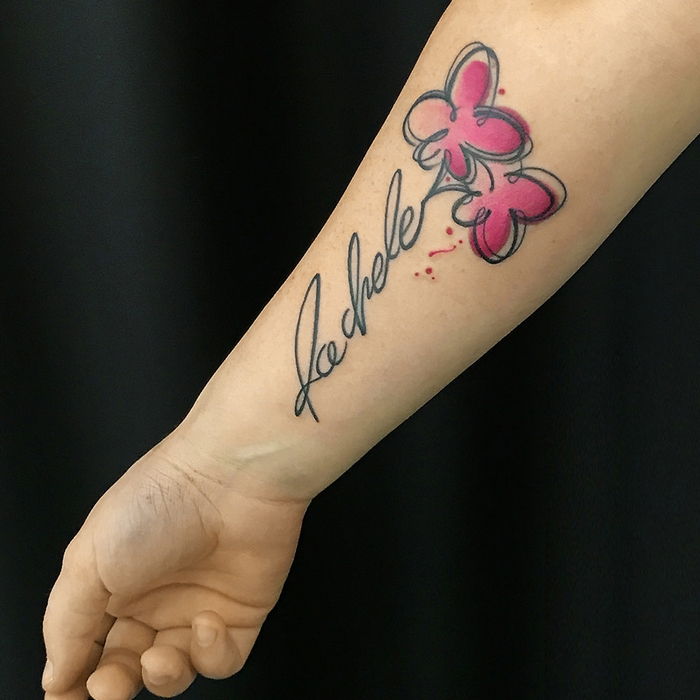 två rosa blommor och en inskription ganska stilfull vattenfärg tatuering