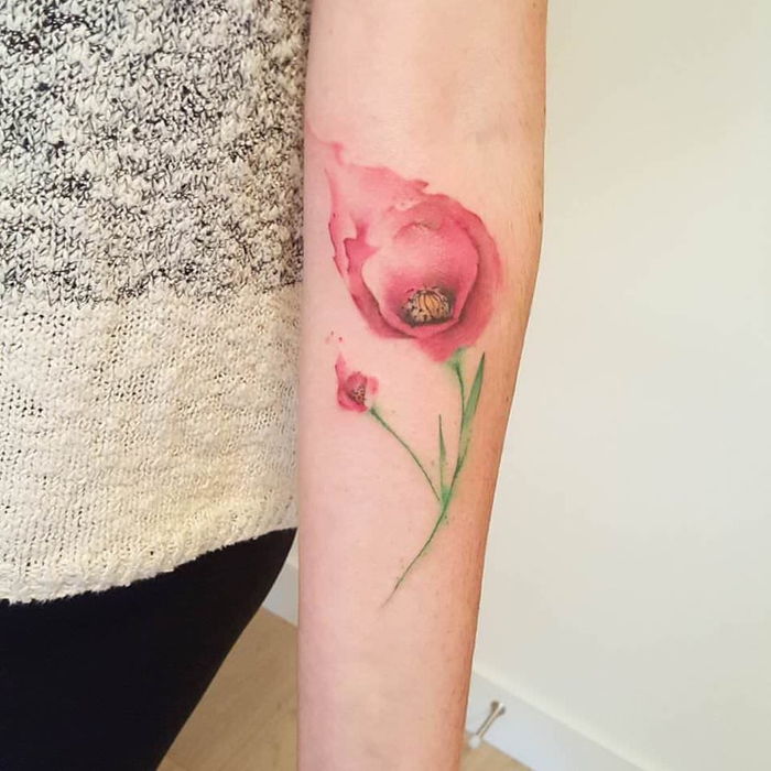 röd blomma med små och stora blommor och korta gröna blad vattenfärg tatuering