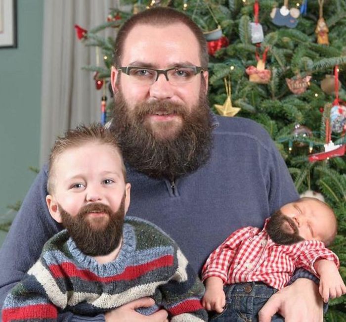 Imagini de Crăciun - Tatăl și doi copii au aceeași barbă în fața pomului de Crăciun