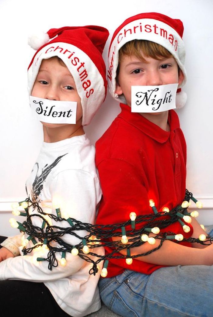 doi băieți sunt legați cu un șir de lumini - fotografii ridicole de Crăciun