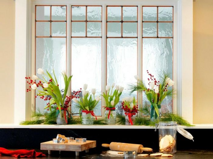 Kuchyňa okno s bielymi tulipány s dlhými svetlo zelené listy, vložíme do pohárov, ozdobených červenými stužkami a malé imela s červenými plodmi, Holztbrett s mnohými Ausstechfoormen nasadiť červený bavlnený uterák, čerstvo upečený Ingweirkekse, cesto sa valček, kuchynský stôl posypaný múkou, dobre pomúčenej doske