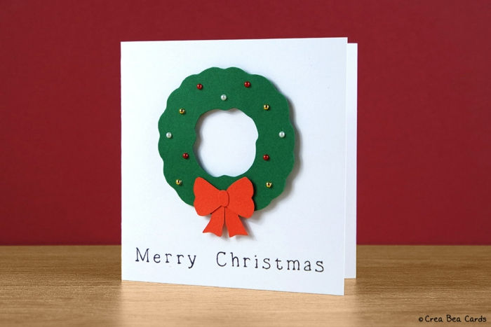 Vianočná karta vyrobená sami, vianočný veniec zo stavebného papiera, zdobený farebnými korálkami