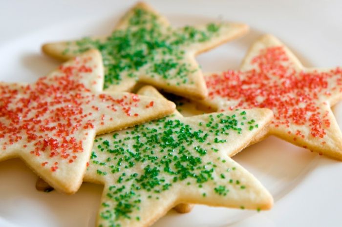 Praznični sladkorni piškoti v obliki zvezd, posuti z rdečim in zelenim sladkorjem.