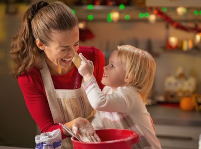 Baby prøver å smøre mødre nese med mel mens du lager julekaker