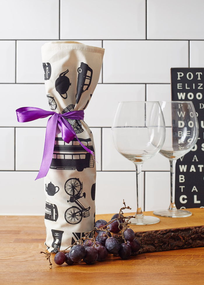 Förpackning vinflaskor med tyg, lila band, dekorering och avgivande vin