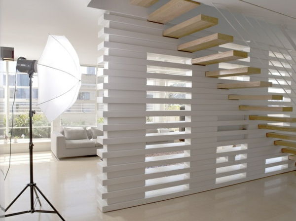 Escada de madeira flutuante no estúdio com design de parede extravagante