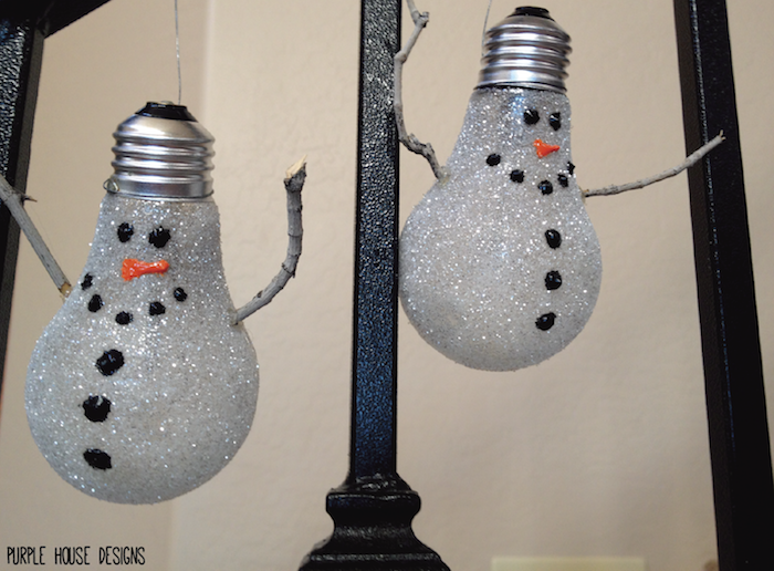 diy snögubbar från glödlampor - med små svarta ögon och svarta knappar och en orange näsa - tinker snögubbe